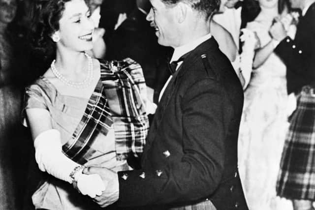 Princess Elizabeth of York, future Queen Elizabeth II, wearing a gown of lime green with a royal stuart tartan sash, dances with David Bogle at the Aboyne Ball, on September 9, 1949 during the Royal couple’s holidays in Scotland. (Photo by INTERCONTINENTALE / AFP) (Photo by -/INTERCONTINENTALE/AFP via Getty Images)