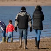 Family playing at the seaside in winter, Instow, Devon, UK. (Photo by: Education Images/Universal Images Group via Getty Images)