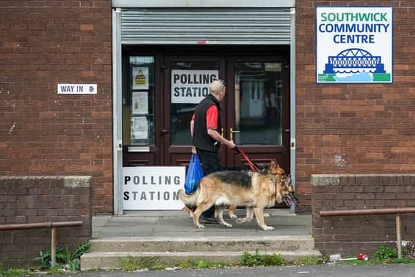 Man takes a dog to a polling station