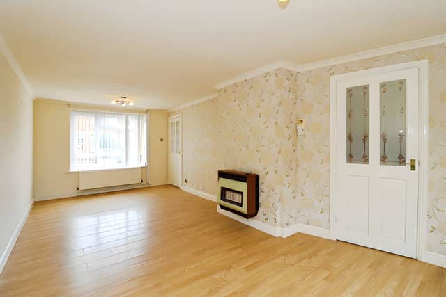 Large windows bring natural light into the spacious open-plan lounge and dining room, creating a flexible central living space