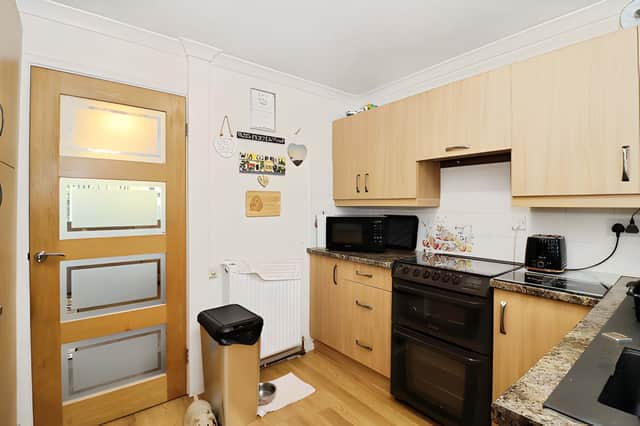 The fitted kitchen provides a practical cooking space with a range of storage units and easy access to the rest of the bungalow
