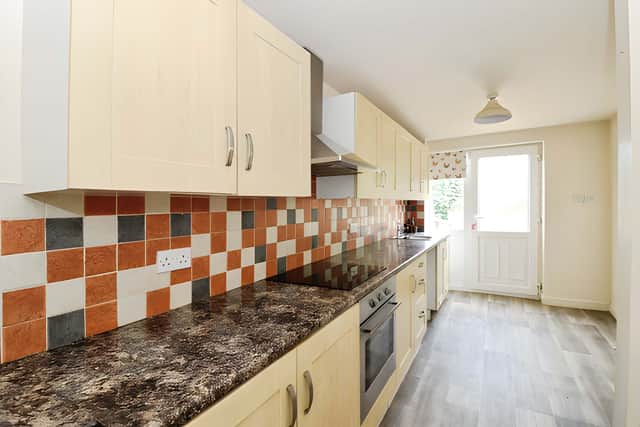 The fitted kitchen combines wall and base units with generous worktop space and storage for practical everyday use