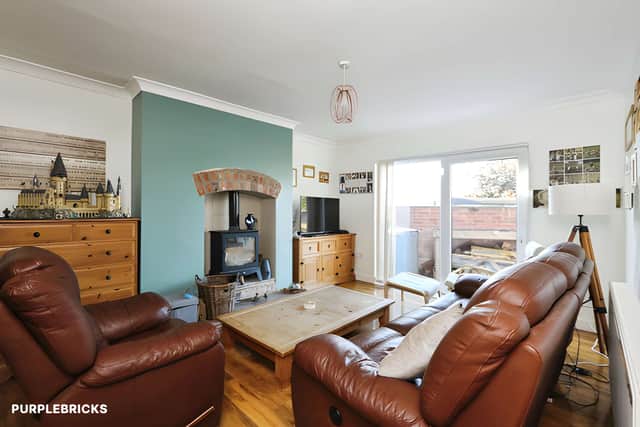 Exposed brickwork frames the log-burning stove in the lounge, while French doors open directly onto the rear garden.