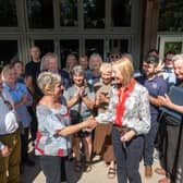 Cathy Cooke, a Director of the Derbyshire Eco Centre CIC, shaking hands with Dr Helen Bailey, Chair of the Institute of Quarrying, surrounded by team members of the Institute of Quarrying and Derbyshire Eco Centre CIC.
