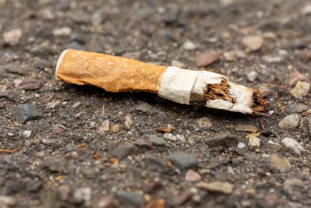 A discarded cigarette butt on the ground