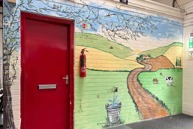 A wall-mounted tap has been worked into the mural, turning an everyday feature of the market into part of the artwork.