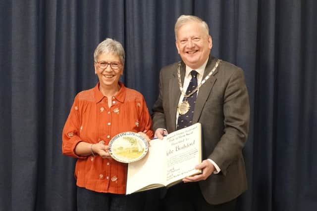 Chairman of Holymoorside & Walton Parish Council, Cllr Martin Thacker MBE, presents Mrs Kate Brailsford with the 2026 Pride of the Parish Award in recognition of her 25 years of dedicated service as Parish Clerk.