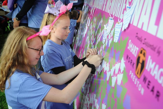 Amelia Atack (left) and Lily Alker add memories of their grandads to the memory wall.