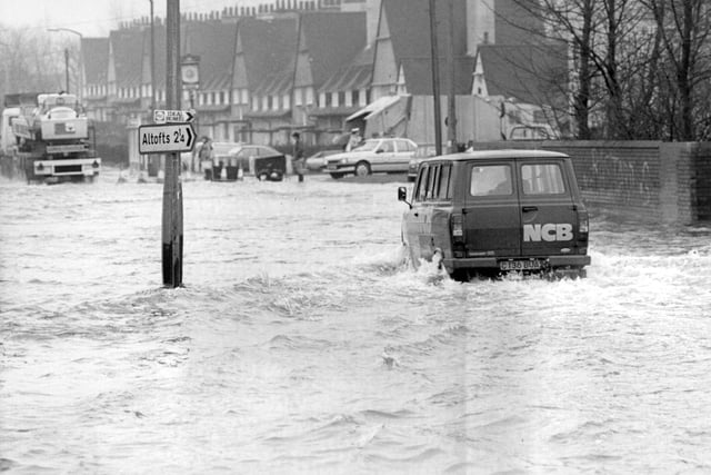 Taken in the 1970s from above the Rising Sun public house and looking towards Normanton. A lorry and a van pass through flood water which has backed up through the drains.