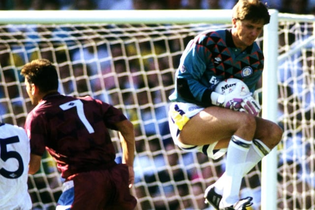 John Lukic claims the ball under pressure from Manchester City's David White.
