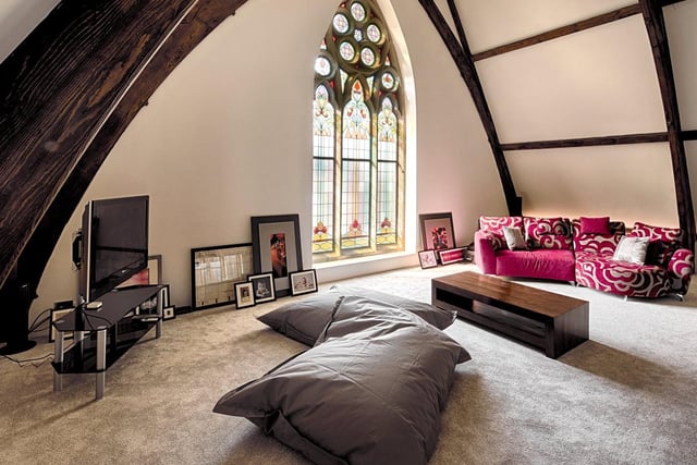 Stairs leading to the stunning mezzanine level which features the most exquisite stained glass window and provides a striking view over the living space below. A fabulous curved vaulted ceiling with beautiful wooden beam features, and glazed balustrade gives an even greater feeling of space.
