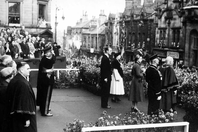 Crowds lining Queen Street to greet Queen Elizabeth II accompanied by the Duke of Edinburgh. The party, including the Mayor of Morley, Alderman Joseph Rhodes and the Mayoress, his sister Miss Alice Rhodes, are in front of Town Hall