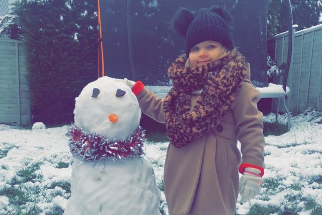 Sophie Oesterlein's little girl shows off a snowman almost as big as she is!