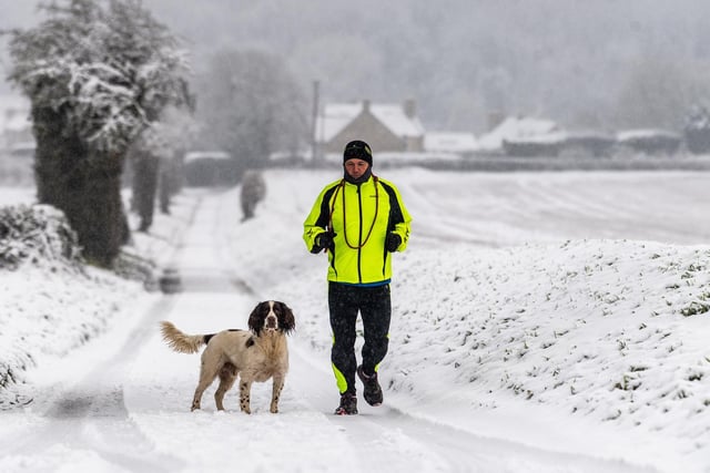 Paul Chadwick and dog Lenny ventured out on the snow covered country lane near the village of Stutton, near Tadcaster, North Yorkshire early this morning.