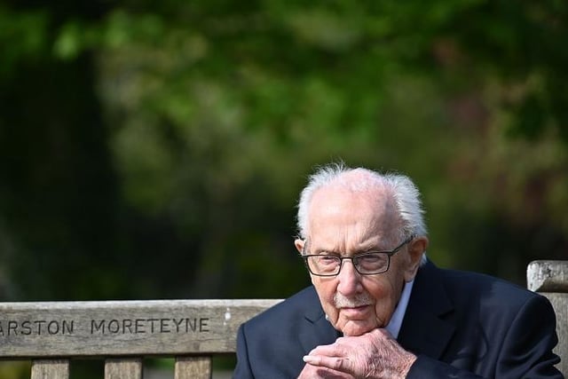 British World War II veteran Captain Tom Moore, 99, does up his tie as he sits on a bench in the village of Marston Moretaine, 50 miles north of London