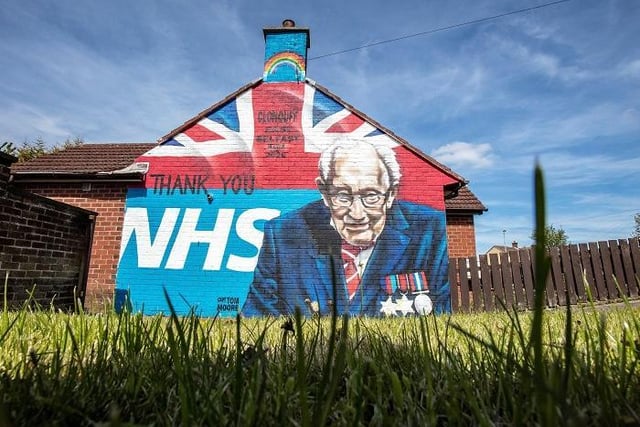 A street art graffiti mural, showing the logo of the NHS, and an image 100-year-old veteran Captain Tom Moore who raised over GBP 30 million for NHS charities, is pictured in east Belfast on May 5, 2020