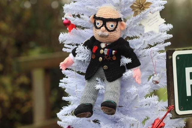 A hand knitted Christmas bauble of Captain Sir Tom Moore hangs on the village Christmas tree in the centre of Allington, Lincolnshire.