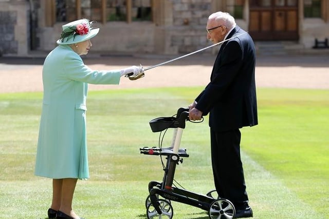 Queen Elizabeth II uses the sword that belonged to her father, George VI as she confers the Honour of Knighthood on 100-year-old veteran Captain Tom Moore at Windsor Castle