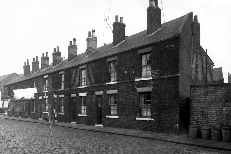 This 1950s view shows the cobbled back-to-back terraces of Douro Street in Wortley. Lines are hung with washing extend from houses across the cobbled streets to attach with houses opposite.