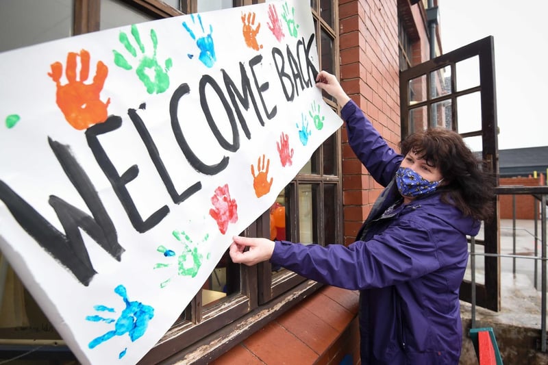 Year 4 teacher Paula Storton hangs up a welcome sign before the arrival