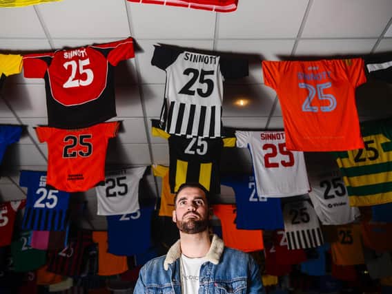 Jordan Sinnott's brother Tom looks at the vast collection of 826 football shirts with Sinnott printed on the back