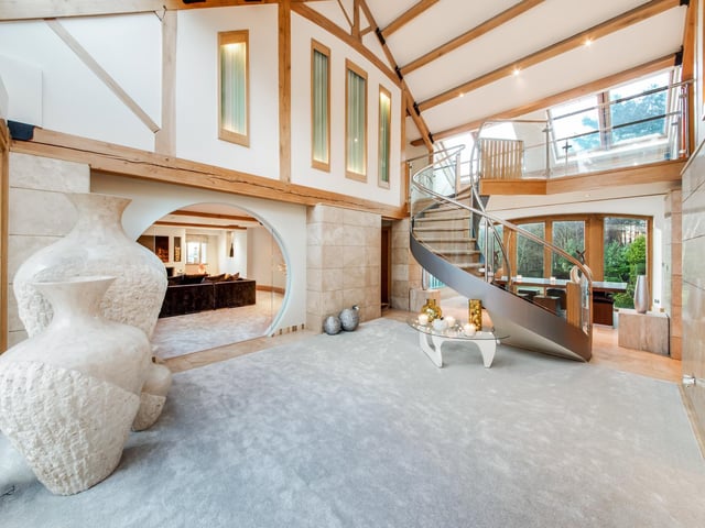 A curved staircase is a feature of this stunning hallway.