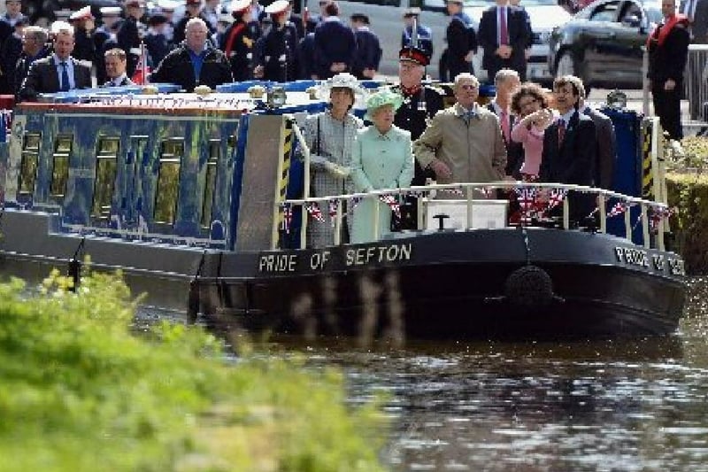 Queen Elizabeth II, The Duke of Edinburgh and The Prince of Wales (hidden right)  make their way along the Leeds and Liverpool canal on the barge 'Pride Of Sefton', during a trip to Burnley, Lancashire