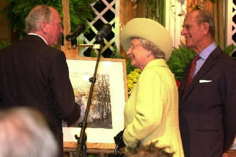 The Queen is presented with a painting during her visit to Preston