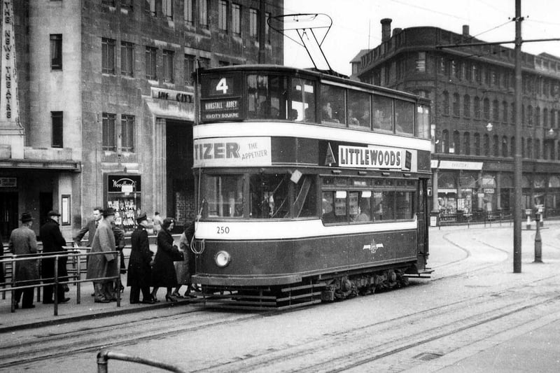 People queueing to board Horsfield tram no.250 in City Square in March 1952. This tram, bound for Kirkstall Abbey on route no.4, is advertising Tizer soft drink and Littlewoods pools.