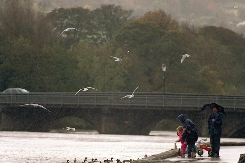 October 1998 and a family braves the weather as the River Wharfe swells in Otley.