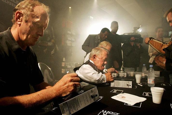 Fans of Star Wars trilogy movies ask to actors Kenneth Colley (L) alias Amiral Piettto, Kerny Baker (C) alias R2-D2 and Jeremy Bulloch alias Boba Fett to sign autographs on their DVD box during the first sale at a famous store on Les Champs Elysees in Paris, early 21 September 2004
