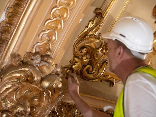 A craftsmen gives the ballroom ceiling a fresh look