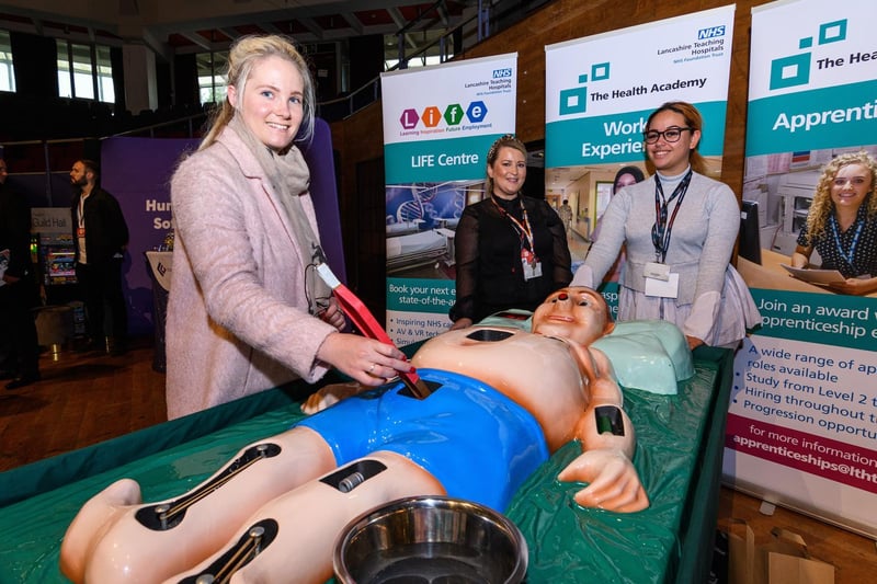 Rosie Burton from RJ Accounting Services tries out a life-sized operation game with Karen Gore and Olivia Dymond from Lancashire Teaching Hospitals at Lancashire Business Expo at Preston's Guild Hall.