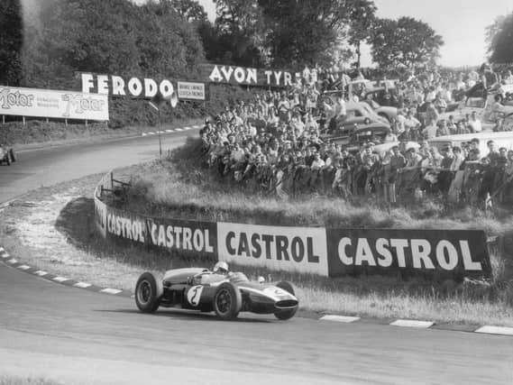 Crowds packed on grass banking to see Aussie Jack Brabham rounds one of the famous Silverstone bends during the Silver City Trophy race for Formula 1 cars in 1960. Photos: Getty Images