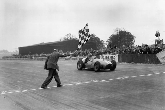 Froilan Gonzalez takes the winning flag in his Ferrari 375 at the 1951 British GP, beating fellow Argentian Juan Manuel Fangio into second place. The legendary Fangio went on to win five world titles between 1951 and 1957  a record only surpassed when Michael Schumacher won his fifth F1 crown in 2002