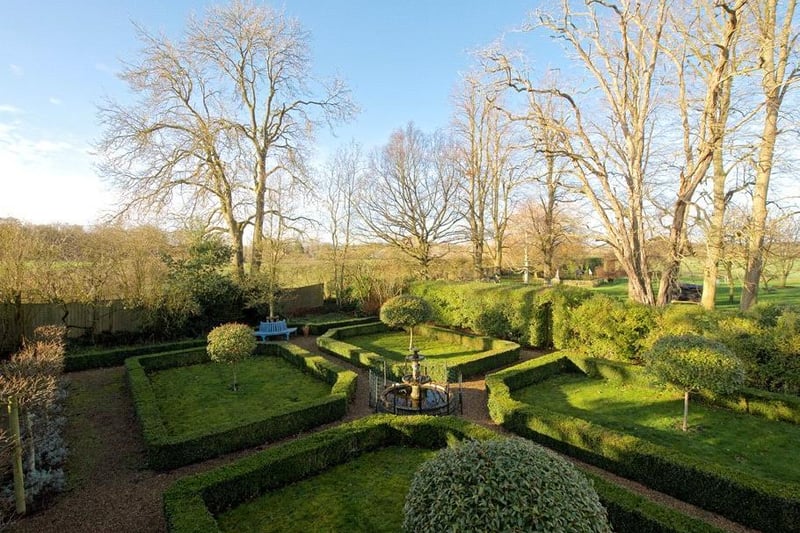 The main formal garden is also lawned with a variety of mature trees, and a chicken run .There is a large natural pond which is enclosed by fencing and has an island in the centre.
