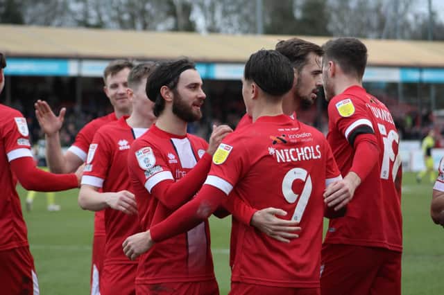 Crawley Town players celebrate with goalscorer Tom Nichols after his first strike against Stevenage