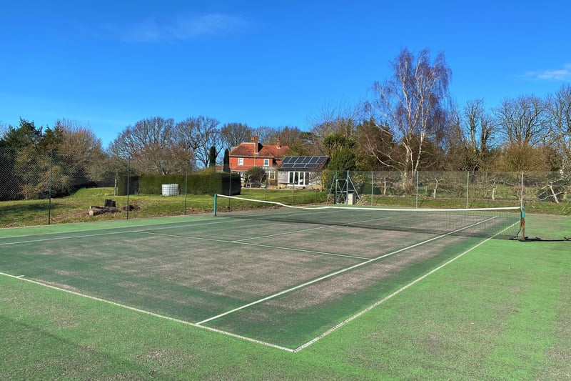 The grounds also include a tennis court (pictured), a four-acre paddock and a wildflower meadow