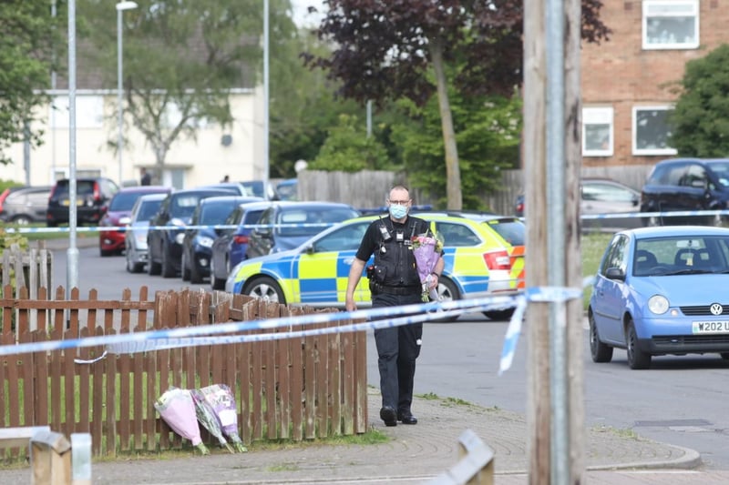 Officers have been moving floral tributes left by residents inside the cordon