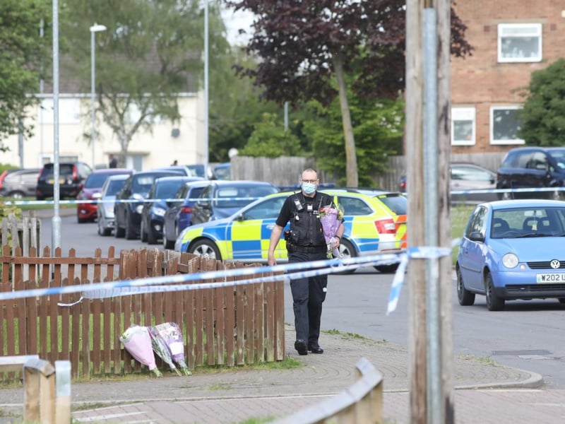 Officers have been moving floral tributes left by residents inside the cordon