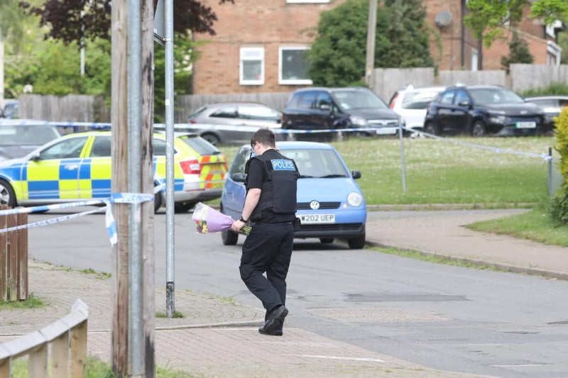 An officer with flowers at the scene