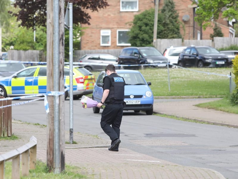 An officer with flowers at the scene