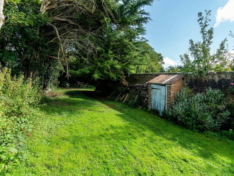 The garden is mainly laid to lawn, surrounded by mature hedgerows and trees, with a small kitchen garden and fruit trees. Picture: Savills Haywards Heath.