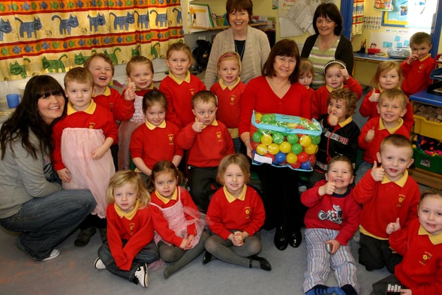 Audrey Stewart from the Ulster Teachers Union presents a prize to the children from Ballykeel PS nursery department from the UTU Winter/Christmas art competition