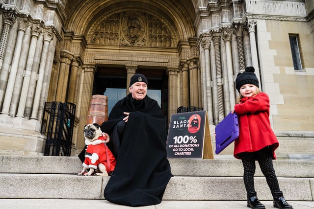 The Dean of St Anne's Cathedral Belfast launching his annual Black Santa stand out with Rowan Wylie who is making her donation online. Picture: Elaine Hill