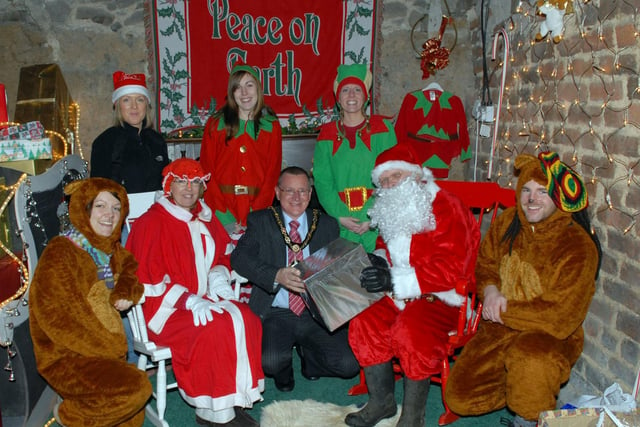 Craigavon Mayor Robert Smith receives a gift from Santa and Mrs Claus during a vist to his grotto at Love for Life in Waringstown. icluded are santa's helpers, from left, Ollie the Bear, Holly Heather, Cheeky Carla, Jolly Jane and Will Bear