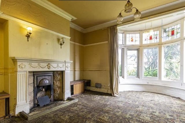The bay-fronted reception room has a fireplace with open grate and an ornate surround. The original Victorian picture rail and coving is still in situ.