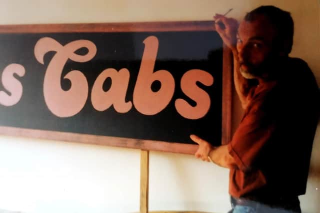 David Hill beside his handpainted sign for Babs Cabs.