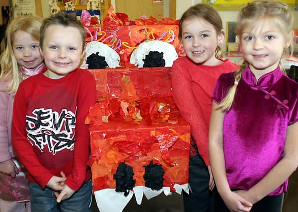 Charlotte Oxley, Connor Gregory, Caitlin South and Gemma Barthorpe with a Chinese dragon at Whitecotes School, Chesterfield.