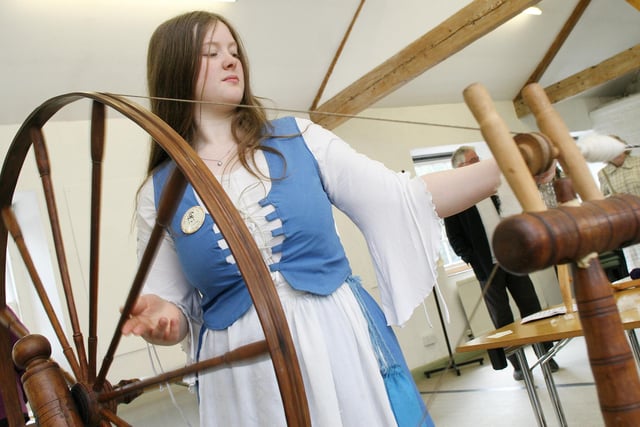 Handspinner Diane Fisher of the Awkwright Spinsters skillfully spins a yarn of Lincolnshire longwool on an authentic 1870s Great Wheel at the Georgian Re-Enactment weekend at Cromford Mill in 2009